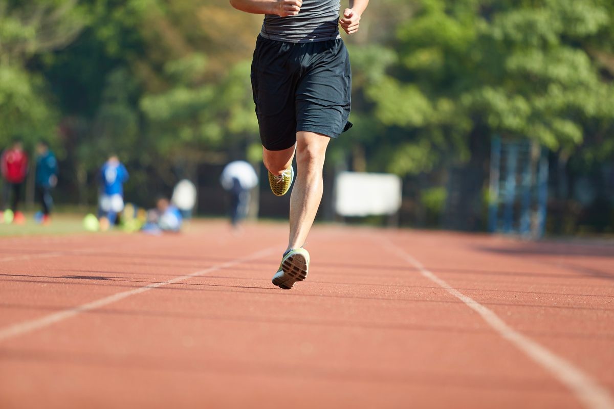 young asian man male athlete running training exercising on track.